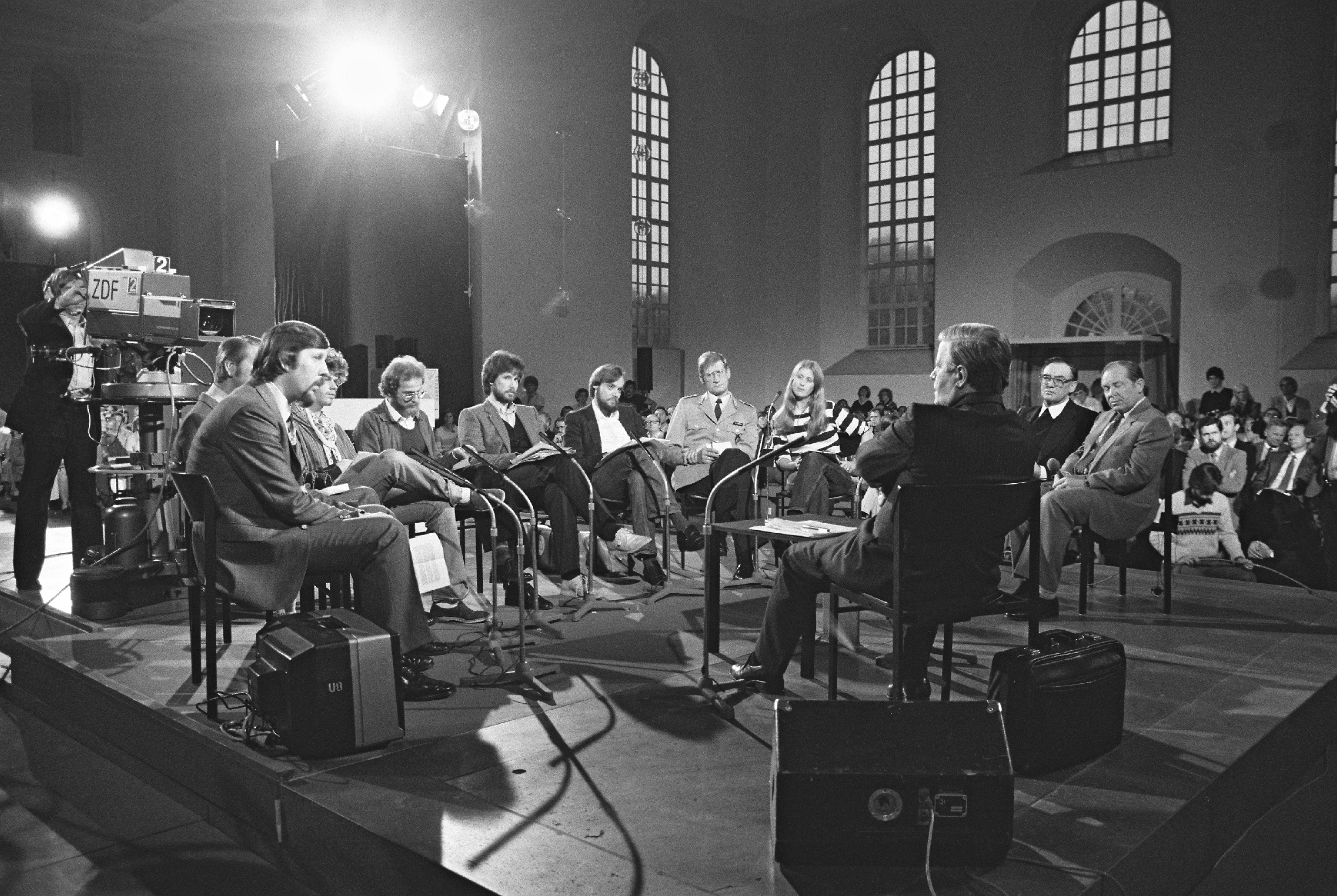Helmut Schmidt sitzt jüngeren Menschen gegenüber, die ihm Fragen stellen können, im Hintergrund eine Fernsehkamera des ZDF.