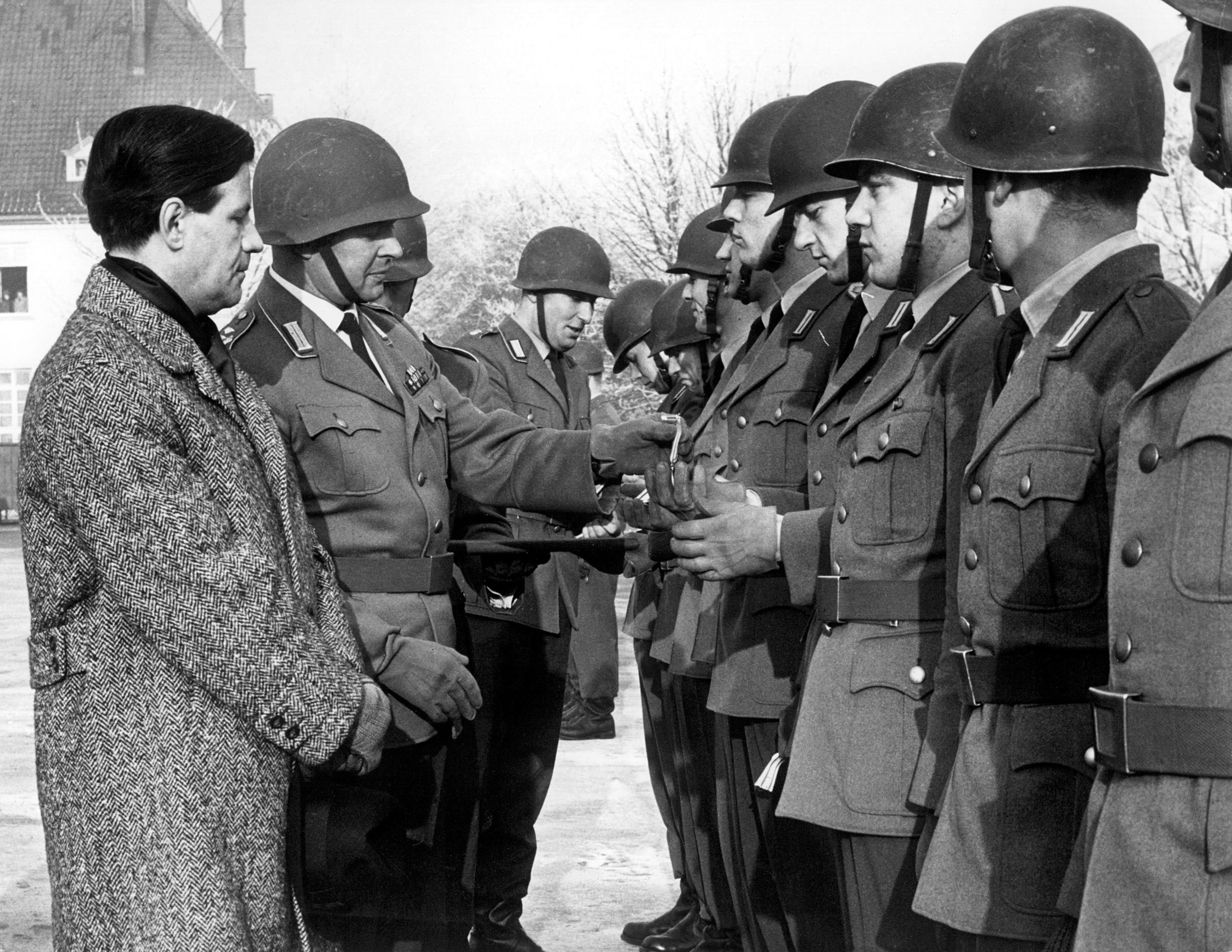 Innensenator Helmut Schmidt zeichnet auf einem winterlichen Kasernenhof Soldaten aus.